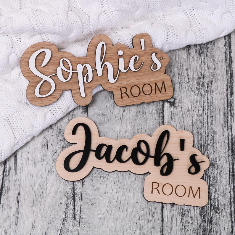 May include: Two wooden signs with the names "Sophie's Room" and "Jacob's Room" written in black and white lettering.