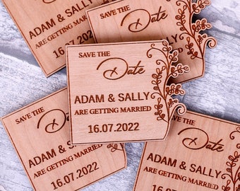 May include: Four wooden save the date cards with a floral design and the text "Save the Date" and "Adam & Sally are getting married" with the date "16.07.2022".