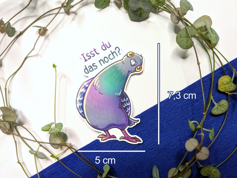 Puede incluir: Una pegatina troquelada con una paloma de dibujos animados con plumas iridiscentes moradas, verdes y azules. La paloma tiene grandes ojos amarillos y mira hacia atr&aacute;s. El texto "Isst du das noch?" est&aacute; impreso sobre el ave. Mide 7,3 cm por 5 cm.