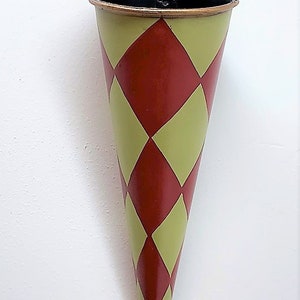 May include: A red and green cone-shaped metal planter with a diamond pattern. The planter has a metal loop at the top for hanging.
