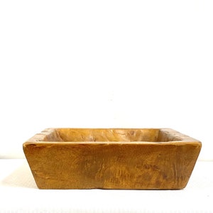 May include: A rectangular wooden serving bowl with a natural wood finish. The bowl is made of solid wood and has a rustic look.