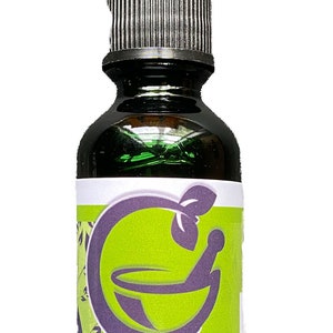 May include: A dark green glass bottle with a black dropper top. The label features a green and purple design with the words "CREOLE CURE" and "Manglier Tea Concentrate".