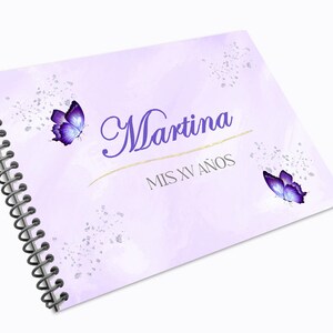 Puede incluir: Libro de visitas de espiral morado con el texto "Martina Mis XV Anos" y dos mariposas moradas sobre un fondo morado claro.