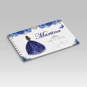 Puede incluir: Un cuaderno con espiral y cubierta blanca con borde floral azul. La cubierta incluye el nombre "Martina" en cursiva, una ilustración de una mujer con un vestido azul y el texto "MIS XV AÑOS". También hay una mariposa azul y estrellas.