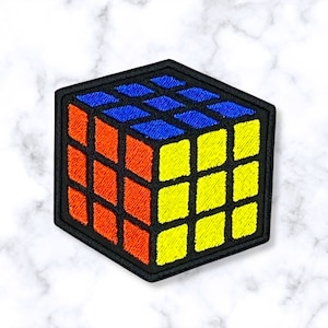 May include: A black, red, blue, and yellow embroidered patch of a Rubik's Cube.