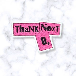 May include: Pink fabric patch with the text "Thank Next U," in black lettering.