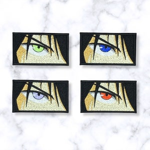 May include: Four embroidered iron-on patches featuring a close-up of an anime character's eye. The eyes are green, blue, purple, and red.