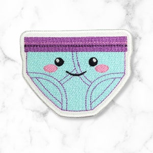 May include: A light blue embroidered patch shaped like underwear with a purple waistband and a smiling face.