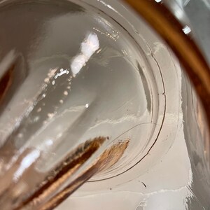 K&ouml;nnte beinhalten: Nahaufnahme des Inneren eines durchsichtigen Glaskrug mit braunem Rand. Das Glas ist leicht strukturiert und hat einen kleinen Riss am Rand.