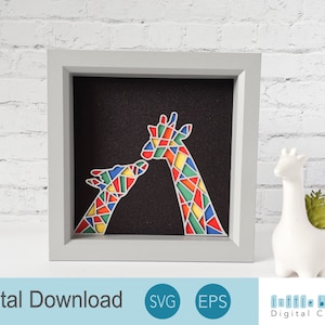 May include: A framed digital download of two colorful geometric giraffes kissing. The giraffes are made of multi-colored geometric shapes, including red, yellow, green, blue, and orange. The background is black.