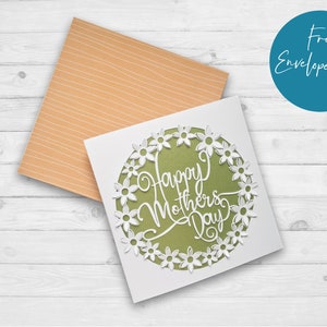 May include: A white card with a green circle and white flowers around the edge. The text "Happy Mother's Day" is written in white inside the circle.
