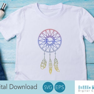 May include: A white t-shirt with a colorful dreamcatcher design. The dreamcatcher has a circle with the word "Dream" inside and feathers hanging from the bottom.