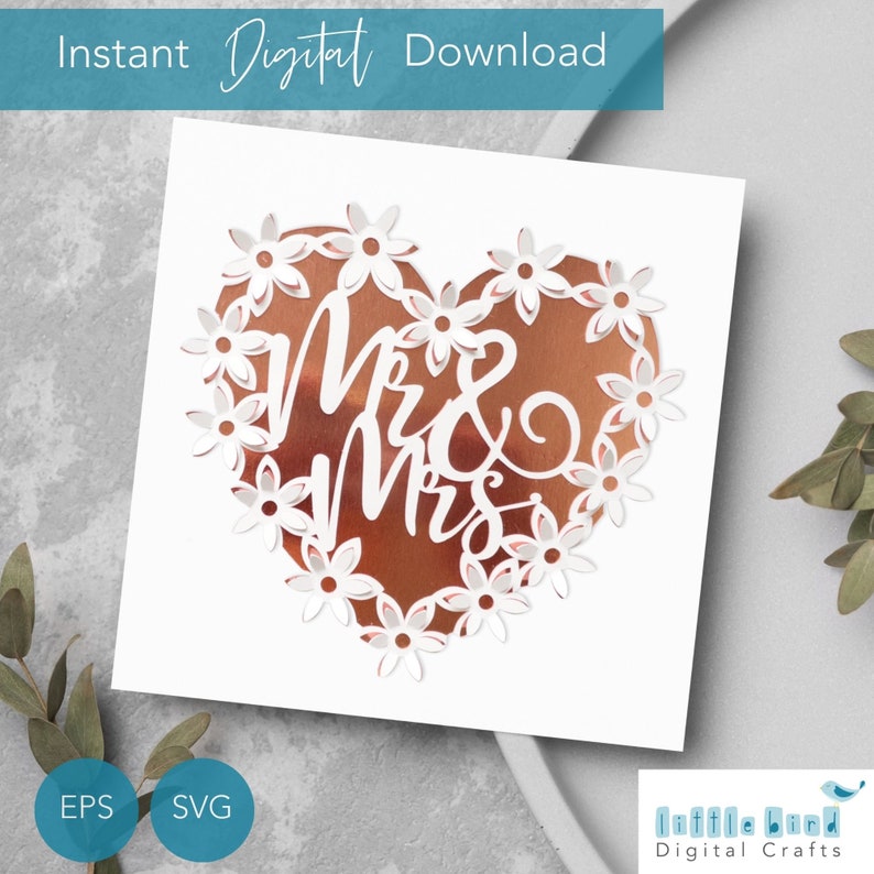 Puede incluir: Texto blanco 'Mr & Mrs' en forma de coraz&oacute;n con un borde floral blanco sobre un fondo de cobre.