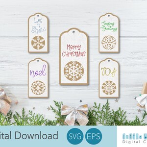 May include: Set of six Christmas gift tags featuring snowflake designs and various festive greetings, including "Let It Snow", "Noel", "Merry Christmas", "Seasons Greetings", and "Joy".