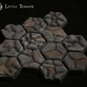May include: A set of 12 grey and brown hexagonal stone tiles, designed for use in tabletop games and role-playing games. The tiles are made of a textured material that resembles rough stone.
