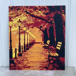 May include: A painting of a park path lined with lampposts and benches. The path is covered in fallen leaves and the trees are a vibrant red and orange. The sky is a soft yellow.