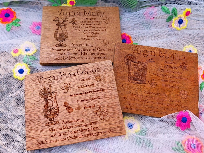 May include: Three wooden coasters with engraved cocktail recipes: Virgin Mary, Virgin Mojito, and Virgin Pina Colada. Each coaster features a detailed illustration of the drink and its ingredients, with text in a decorative font.