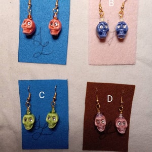 Ceramic Skulls with Rhinestone Eyes Burnt Orange, Blue, Green, and Pink. Each pair costs 7.99