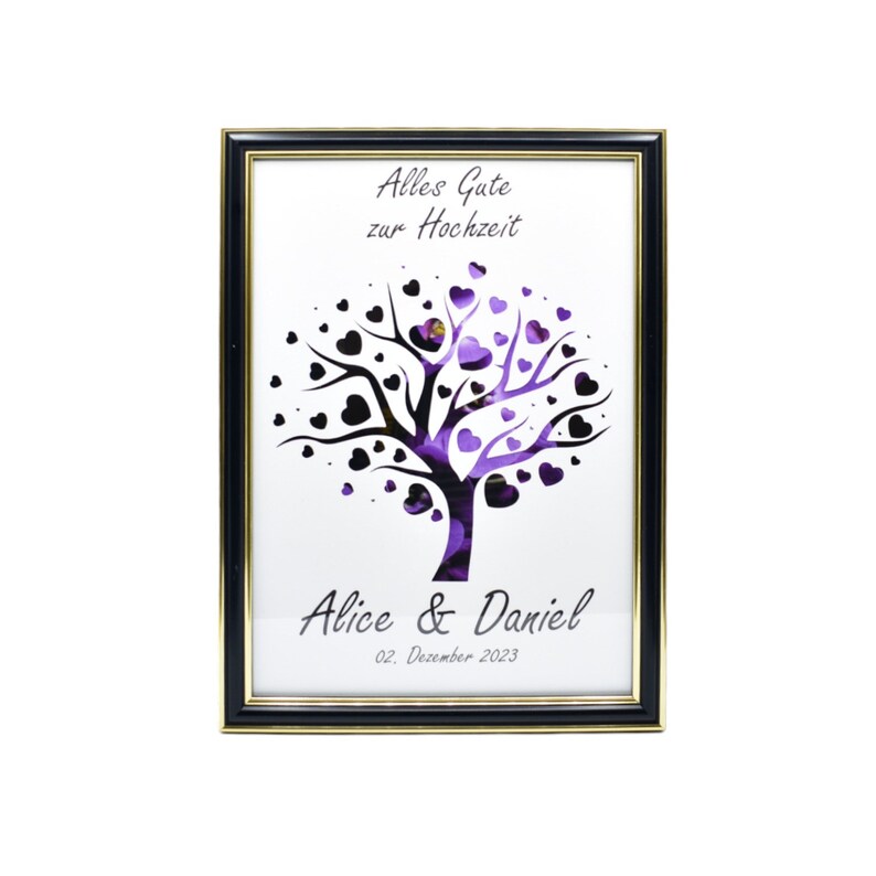 May include: Framed art print featuring a tree design with heart-shaped leaves in black and purple. The text "Alles Gute zur Hochzeit" is at the top, with "Alice & Daniel" and the date below. The frame is black with a gold inner edge.