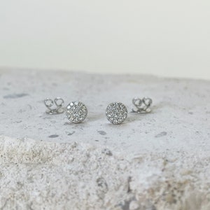 Puede incluir: Un par de pendientes de bot&oacute;n de plata con un dise&ntilde;o redondo de diamantes pav&eacute;.