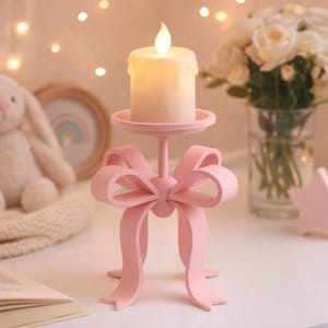 Peut inclure: Un bougeoir rose en forme de nœud. Il possède une base ronde et une plateforme pour accueillir une bougie blanche avec une flamme LED vacillante. Le bougeoir est fait d'un matériau rose uni, un objet décoratif.