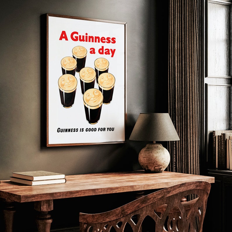 May include: A vintage poster with a brown wooden frame. The poster features a white background with the text "A Guinness a day" in red and black lettering. The poster depicts seven glasses of Guinness beer with smiling faces.