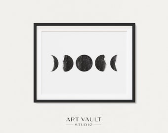 May include: Black and white print of the moon phases in a black frame. The print features five different phases of the moon, from a crescent to a full moon.
