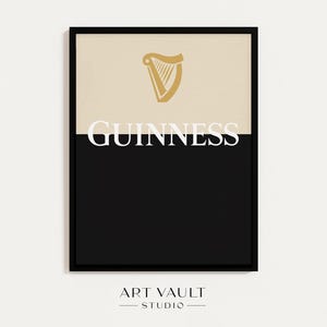 Puede incluir: Impresión artística enmarcada con el logotipo de Guinness. La mitad superior es de color crema con un emblema de arpa dorada. La mitad inferior es negra, con la palabra "GUINNESS" en blanco. La impresión está en un marco negro.