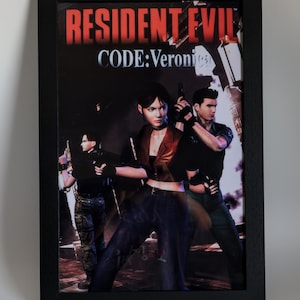 May include: Framed print of the video game Resident Evil: Code Veronica. The artwork features three characters with guns, set against a dark background. The game's title is displayed in red and white text.