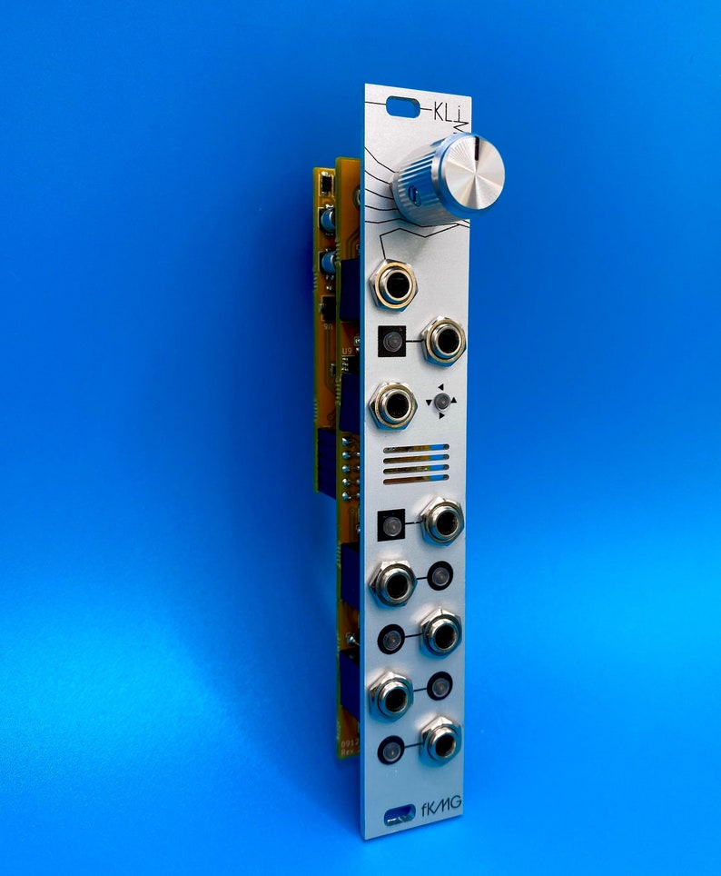 May include: Silver electronic module with multiple input jacks and a large knob. The module has the text "KLI" and "FKMG" printed on it. The module is set against a bright blue background.