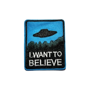 May include: A square patch with a blue background and a black UFO design above a forest silhouette. The text "I WANT TO BELIEVE" is embroidered in white.