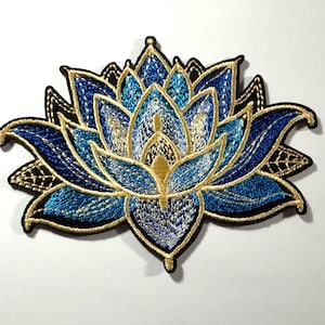 May include: Embroidered lotus flower patch featuring shades of blue, gold, and black. The patch has a detailed design with intricate stitching, a gold outline, and a black border. The lotus flower is a symbol of purity and enlightenment.