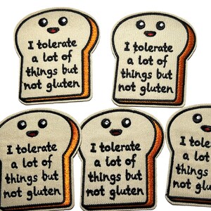 May include: Five embroidered patches shaped like slices of bread with smiling faces. Each patch has the text "I tolerate a lot of things but not gluten" in black letters. The bread is beige with orange crusts.