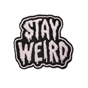 May include: Embroidered patch with the words "STAY WEIRD" in white, dripping font on a black background. The patch has a white border and is likely for clothing or accessories.