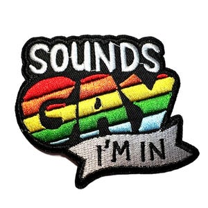 May include: Embroidered patch with the words "SOUNDS GAY I'M IN" in white lettering on a black background. The word "GAY" is in rainbow colors. The patch has a black border and a gray banner with the words "I'M IN".