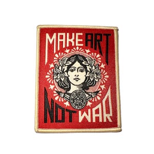 May include: Red and cream-colored patch with the words "MAKE ART NOT WAR" in bold, stylized lettering. The patch features a central illustration of a woman's face surrounded by a floral wreath and a circular emblem. The patch has a gold border.