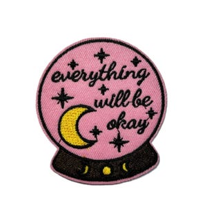 May include: Embroidered patch featuring a pink crystal ball design with the words "everything will be okay" in black script. The patch includes a yellow crescent moon and stars.