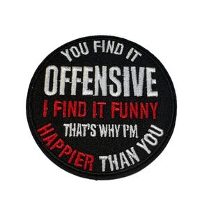 May include: A round, black patch with white and red embroidered text. The text reads "YOU FIND IT OFFENSIVE, I FIND IT FUNNY, THAT'S WHY I'M HAPPIER THAN YOU."