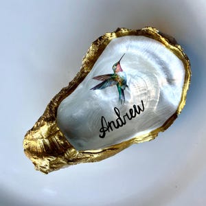 Recuerdos de boda/tarjetas de colocación/regalos de despedida de soltera con diseño de colibrí personalizado, pintados a mano, en concha de ostra dorada/plateada y perlada.