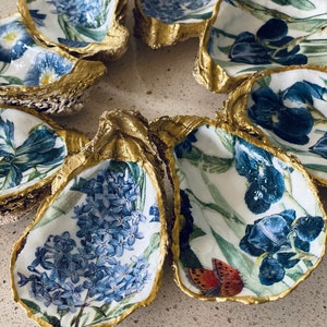 May include: Set of six oyster shell dishes with gold trim. Each dish features a different floral design with butterflies.