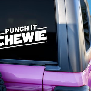 Puede incluir: Un Jeep rosa con una calcomanía de vinilo blanco en la ventana trasera que dice "Punch It Chewie".