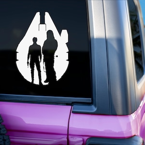 Può includere: Un adesivo in vinile bianco raffigurante il Millennium Falcon con le sagome di Han Solo e Chewbacca. L'adesivo è applicato sul lunotto posteriore di un veicolo rosa, con una spiaggia e una palma sullo sfondo.