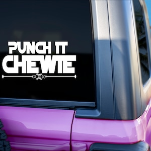 Puede incluir: Un coche rosa con una pegatina de vinilo blanca en la ventana trasera que dice "Punch It Chewie".