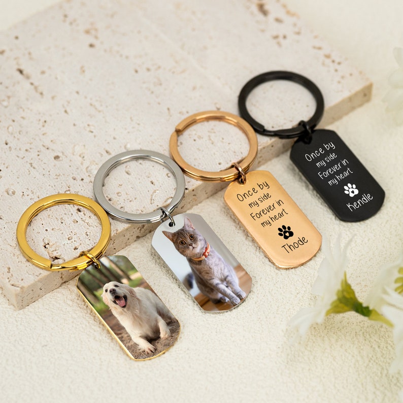 May include: Four silver keyrings with dog and cat photo charms. Each charm has the text "Once by my side Forever in my heart" and a paw print. The keyrings are in gold, silver, and black.
