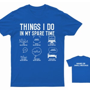 May include: A royal blue t-shirt with a white graphic that says "Things I do in my spare time" and depicts a roller coaster. The graphic includes icons for riding, watching, researching, talking about, thinking about, and dreaming about roller coasters.