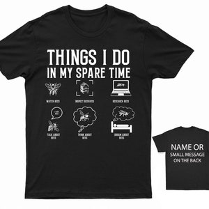 May include: Black t-shirt with white text that reads "Things I do in my spare time". The shirt has a graphic of six bee-related activities: watching bees, inspecting beehives, researching bees, talking about bees, thinking about bees, and dreaming about bees.