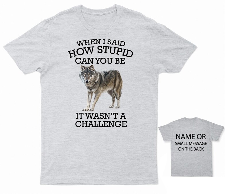 K&ouml;nnte beinhalten: Graues T-Shirt mit einem Wolf-Motiv und dem Text "WHEN I SAID HOW STUPID CAN YOU BE IT WASN'T A CHALLENGE". Auf der R&uuml;ckseite des Shirts steht "NAME OR SMALL MESSAGE ON THE BACK".