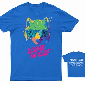 May include: A blue t-shirt with a colorful graphic of a wolf wearing sunglasses and the text "LONE WOLF" in pink and green letters.