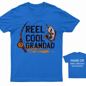 May include: A royal blue t-shirt with a fishing rod and fish graphic. The text "Reel Cool Grandad" is printed on the shirt.
