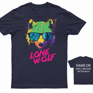 May include: A navy blue t-shirt with a colorful graphic of a wolf wearing sunglasses. The text "LONE WOLF" is printed in pink and white below the wolf.